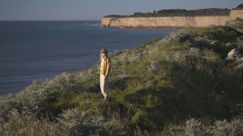 Persona frente al mar sobre los acantilados
