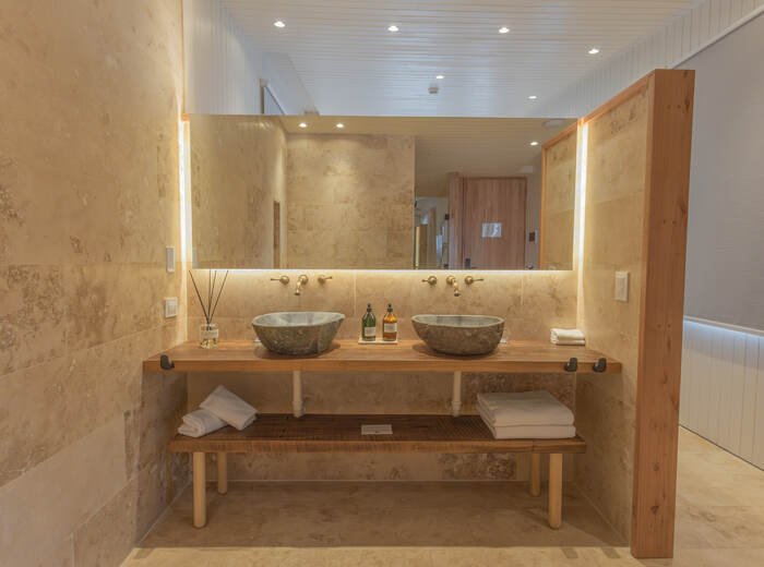 Baño en piedra travertino de una habitación